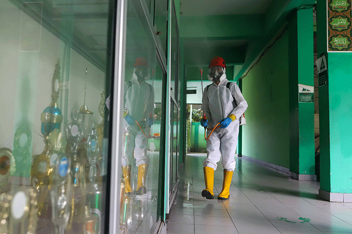 Petugas Palang Merah Indonesia (PMI) menyemprotkan disinfektan di salah satu ruang kelas di SMPN 97, Jakarta Timur, Kamis (3/2/2022).