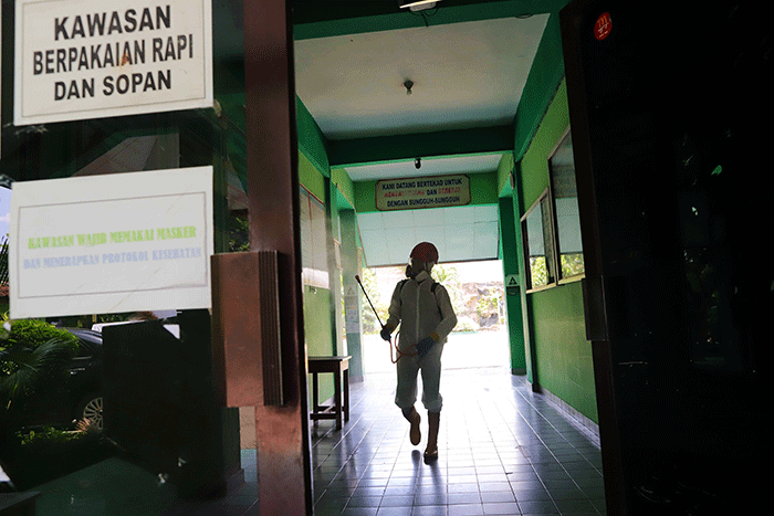 Petugas Palang Merah Indonesia (PMI) menyemprotkan disinfektan di salah satu ruang kelas di SMPN 97, Jakarta Timur, Kamis (3/2/2022).