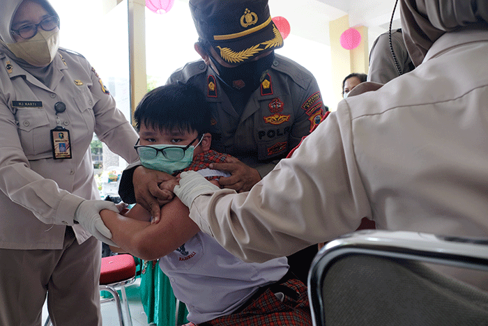 Petugas kesehatan menyuntikan vaksin Covid-19 kepada anak saat mengikuti 'Road Show' vaksin Covid-19 bagi anak usia 6-11 tahun di SD Kristen Hati Kudus.
