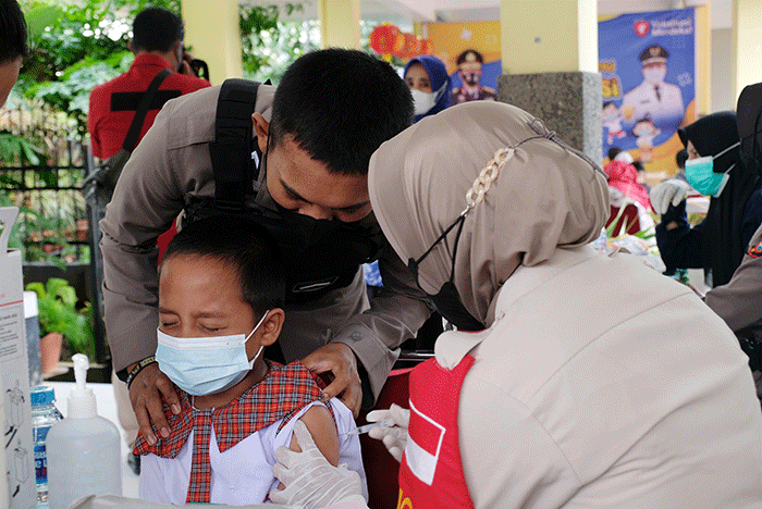 Petugas kesehatan menyuntikan vaksin Covid-19 kepada anak saat mengikuti 'Road Show' vaksin Covid-19 bagi anak usia 6-11 tahun di SD Kristen Hati Kudus.