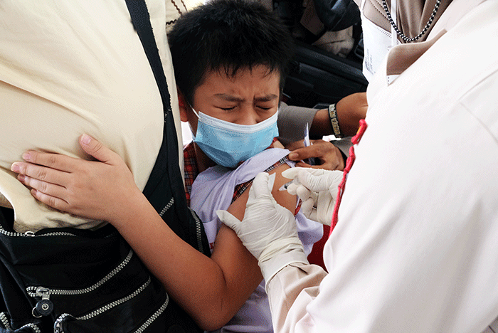 Petugas kesehatan menyuntikan vaksin Covid-19 kepada anak saat mengikuti 'Road Show' vaksin Covid-19 bagi anak usia 6-11 tahun di SD Kristen Hati Kudus.