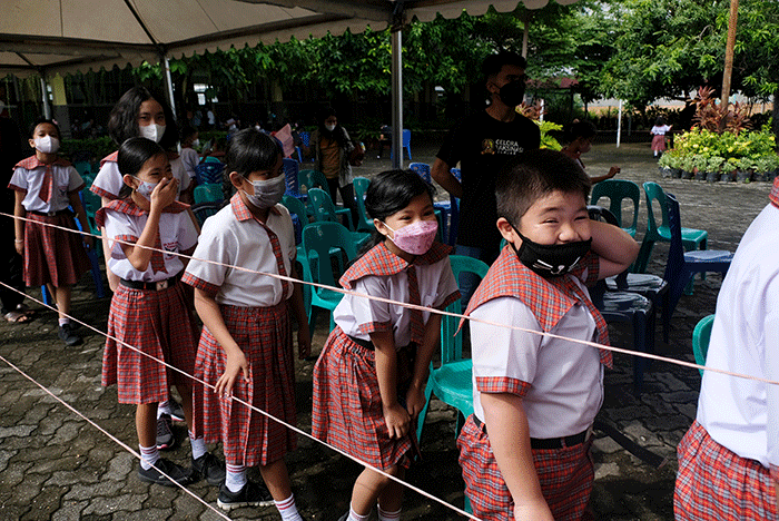Petugas kesehatan menyuntikan vaksin Covid-19 kepada anak saat mengikuti 'Road Show' vaksin Covid-19 bagi anak usia 6-11 tahun di SD Kristen Hati Kudus.