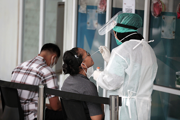 Petugas melakukan tes usap PCR kepada warga di laboratorium Genomik Solidaritas Indonesia (GSI), Jakarta, Kamis (3/2/2022).