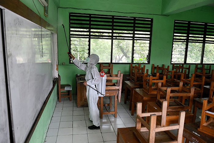 Petugas PMI Jakarta Pusat menyemprotkan cairan disinfektan di SMPN 4, Jakarta, Jumat (4/2/2022).
