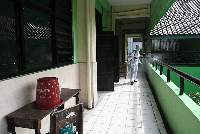 Petugas PMI Jakarta Pusat menyemprotkan cairan disinfektan di SMPN 4, Jakarta, Jumat (4/2/2022).