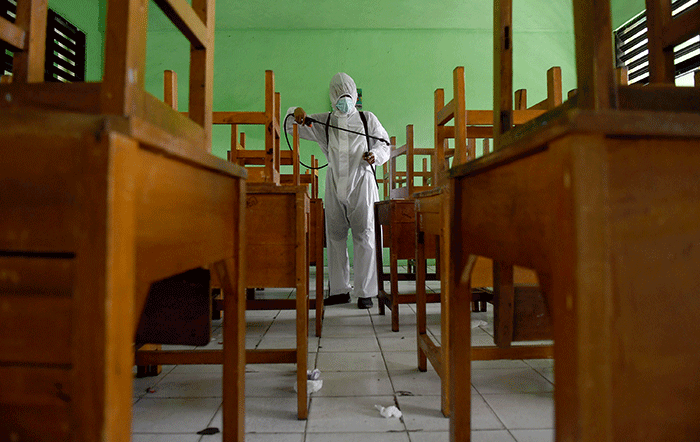 Petugas PMI Jakarta Pusat menyemprotkan cairan disinfektan di SMPN 4, Jakarta, Jumat (4/2/2022).