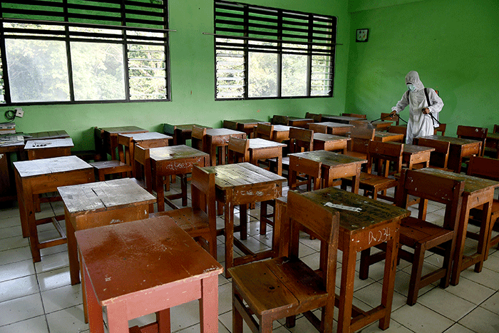 Petugas PMI Jakarta Pusat menyemprotkan cairan disinfektan di SMPN 4, Jakarta, Jumat (4/2/2022).