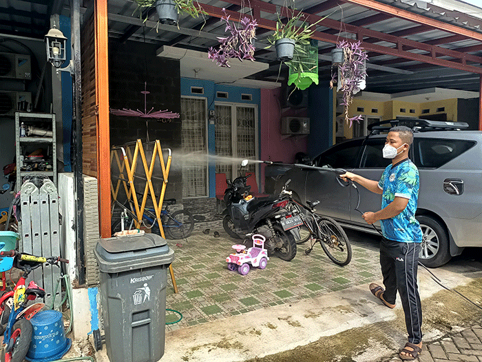 Sejumlah warga menyemprotkan cairan disinfektan secara mandiri di Perum Palm Village, Pamulang, Tangerang Selatan, Sabtu (5/2/2022).