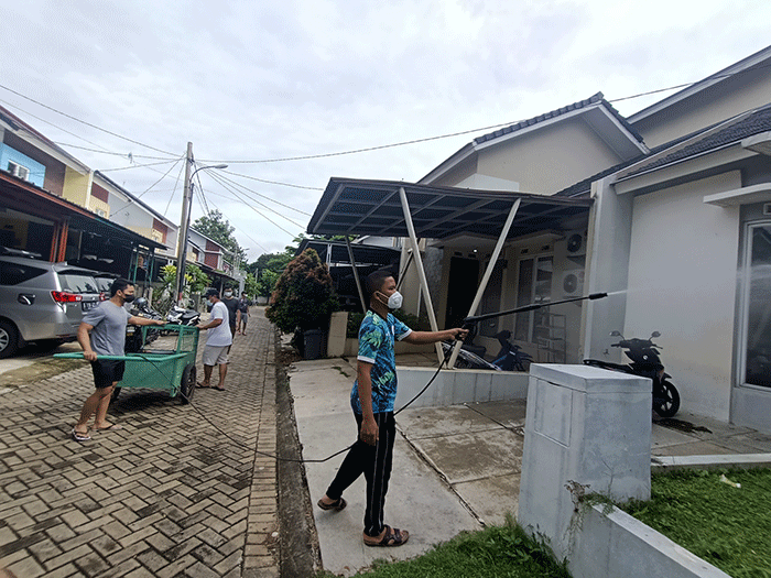 Sejumlah warga menyemprotkan cairan disinfektan secara mandiri di Perum Palm Village, Pamulang, Tangerang Selatan, Sabtu (5/2/2022).