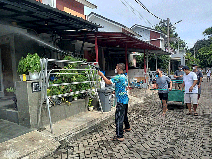 Sejumlah warga menyemprotkan cairan disinfektan secara mandiri di Perum Palm Village, Pamulang, Tangerang Selatan, Sabtu (5/2/2022).