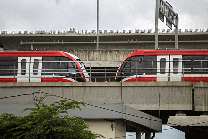 Pengendara sepeda motor melintasi kereta Light Rail Transit (LRT) Jabodebek yang diparkir di kawasan Jakasampurna, Kota Bekasi, Jawa Barat, Minggu (6/2/2022).