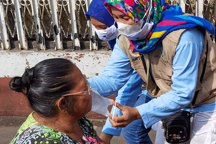 Para ibu-ibu PKK bersama petugas saat mensosialisasikan protokol kesehatan mencegah penyebaran virus Omicron kepada warga Kelurahan Slipi.