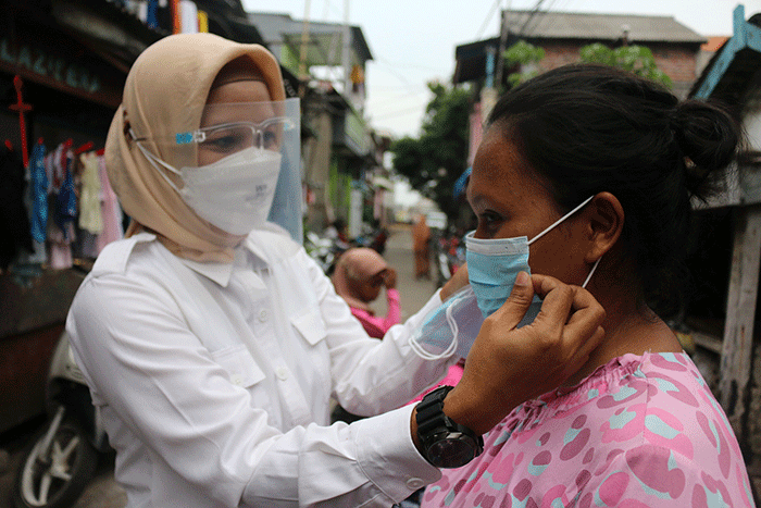 Pembagian masker dan handsanitizer kepada warga Kalibaru, Cilincing, Jakarta Utara, Sabtu (12/2/2022).
