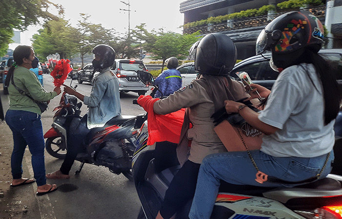 Penjual menjajakkan bunga mawar di Jalan Haji Bau, Makassar, Senin (14/2/2022).