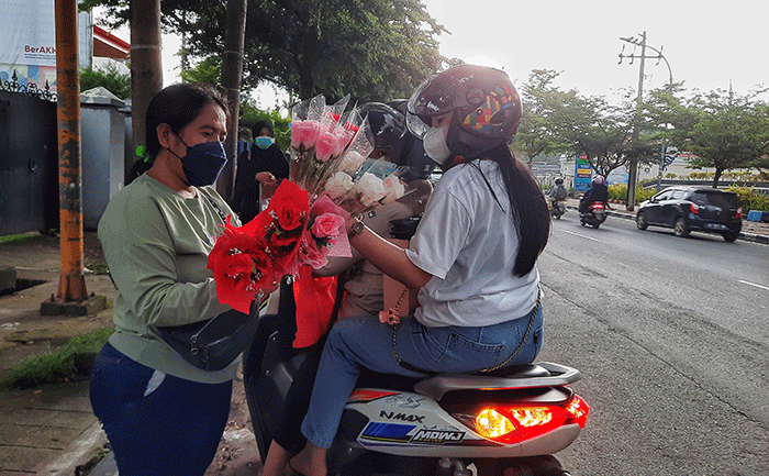 Penjual menjajakkan bunga mawar di Jalan Haji Bau, Makassar, Senin (14/2/2022).