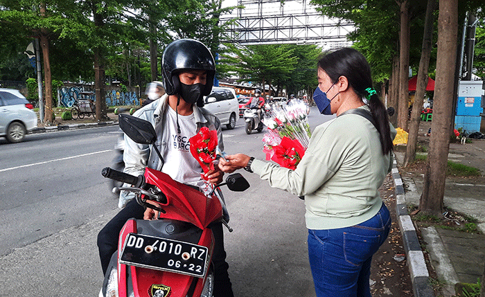 Penjual menjajakkan bunga mawar di Jalan Haji Bau, Makassar, Senin (14/2/2022).