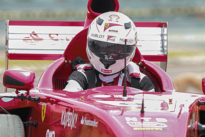 Michael Latip pembuat replika mobil balap F1 saat berpose layaknya pembalap di kawasan Sirkuit Mandalika, Lombok Tengah, NTB, Minggu (13/2/2022).
