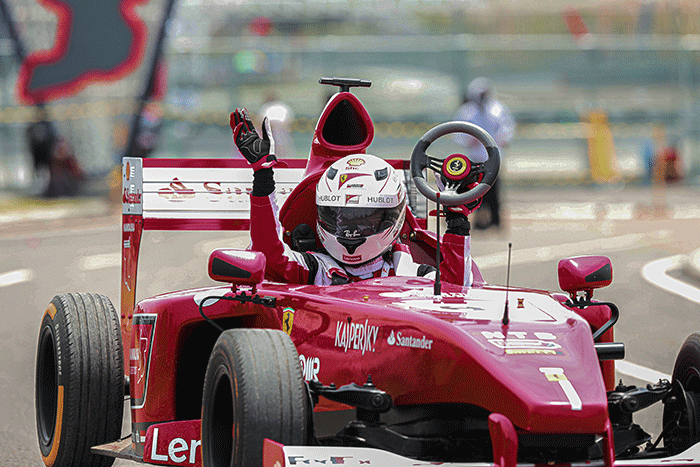 Michael Latip pembuat replika mobil balap F1 saat berpose layaknya pembalap di kawasan Sirkuit Mandalika, Lombok Tengah, NTB, Minggu (13/2/2022).