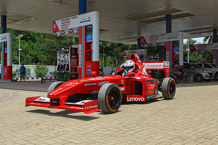 Michael Latip pembuat replika mobil balap F1 saat berpose layaknya pembalap di kawasan Sirkuit Mandalika, Lombok Tengah, NTB, Minggu (13/2/2022).
