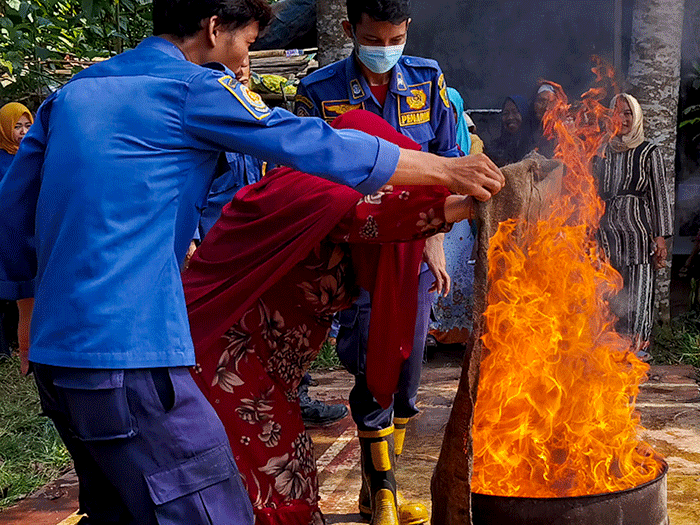 Petugas Dinas Pemadam Kebakaran Kabupaten Bogor melakukan teknik memadamkan api di depan orang tua, guru dan murid PAUD di kawasan Ciseeng, Bogor.