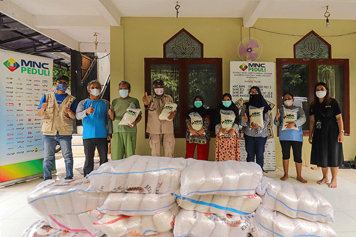 Relawan MNC Peduli saat meberikan bantuan berupa beras kepada warga di kawasan bantaran sungai Ciliwung, Serengseng Sawah, Jagakarasa.