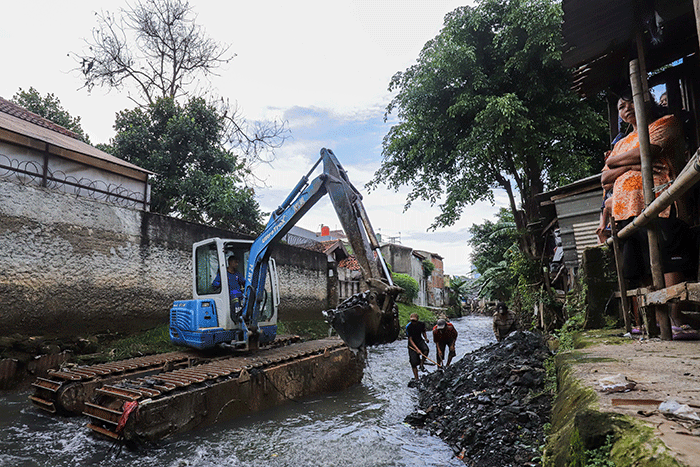 Warga melihat proses pengerukan Kali Mampang di Pondok Jaya, Jakarta Selatan, Sabtu (19/2/2022).