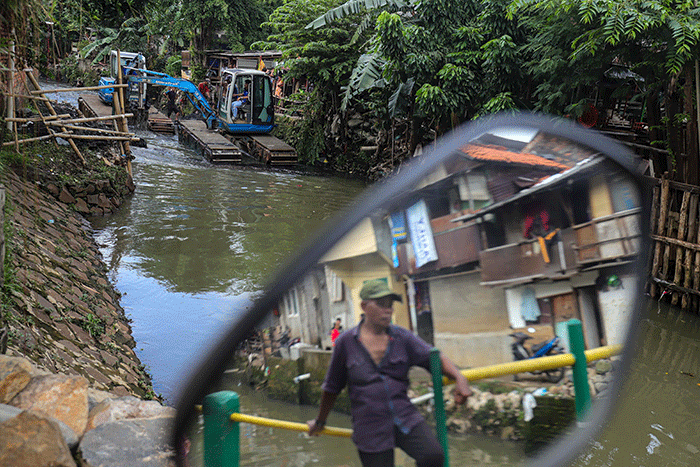Warga melihat proses pengerukan Kali Mampang di Pondok Jaya, Jakarta Selatan, Sabtu (19/2/2022).