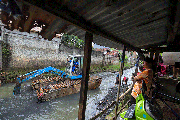 Warga melihat proses pengerukan Kali Mampang di Pondok Jaya, Jakarta Selatan, Sabtu (19/2/2022).