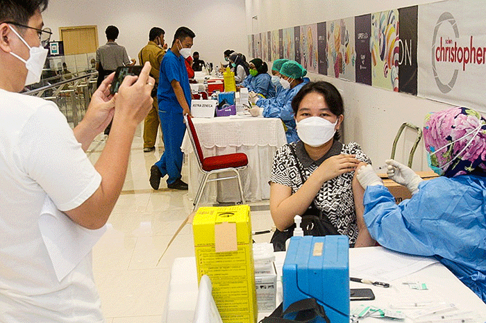 Tenaga Kesehatan menyuntikan vaksin booster Pfizer dan Astrazeneca ke warga untuk mencegah penyebaran Covid-19 di Depok, Jawa Barat, Senin (21/2/2022).