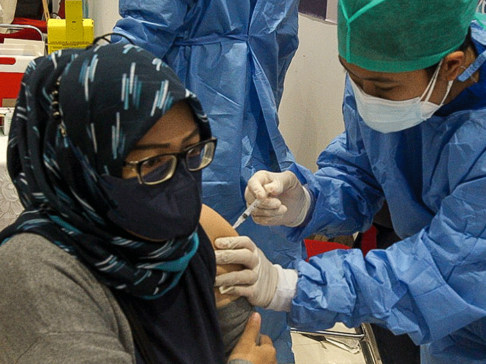 Tenaga Kesehatan menyuntikan vaksin booster Pfizer dan Astrazeneca ke warga untuk mencegah penyebaran Covid-19 di Depok, Jawa Barat, Senin (21/2/2022).