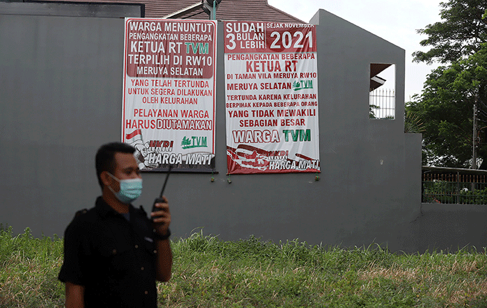 Warga melintasi spanduk meminta pelantikan RT di Meruya di Perumahan Taman Villa Meruya (TMV) Meruya Selatan, Kembangan, Jakarta Barat, Sabtu (26/2/2022).