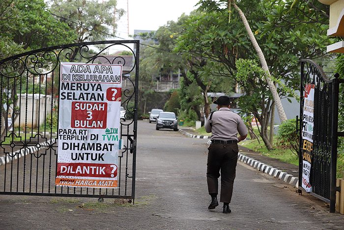 Warga melintasi spanduk meminta pelantikan RT di Meruya di Perumahan Taman Villa Meruya (TMV) Meruya Selatan, Kembangan, Jakarta Barat, Sabtu (26/2/2022).