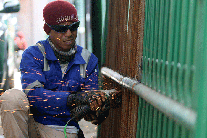 Pelaku UMKM menyelesaikan pembuatan pagar pintu di Cilincing, Jakarta Utara, Sabtu (26/2/2022).