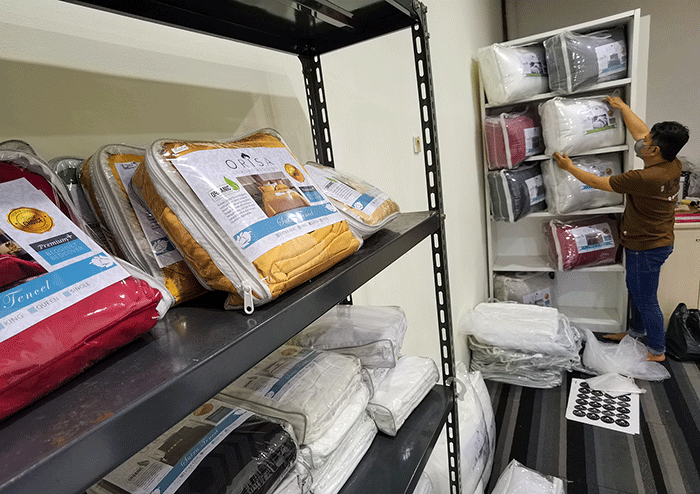 Penjual menata barang dagangannya berupa produk bahan sprei perlengkapan tempat tidur yang dipasarkan melalui online di toko orisa bedding, Jakarta Selatan.