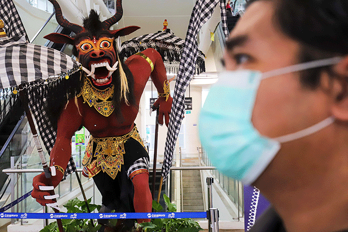 Warga melintasi instalasi Ogoh-Ogoh di Halte CSW Asean, Kebayoran Baru, Jakarta Selatan, Selasa (1/3/2022).