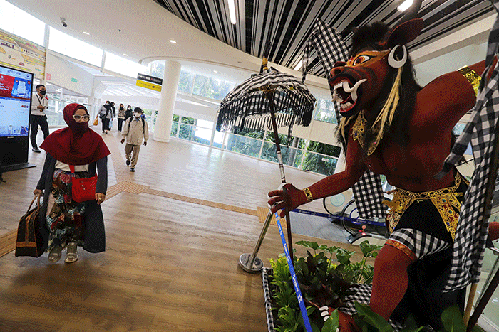 Warga melintasi instalasi Ogoh-Ogoh di Halte CSW Asean, Kebayoran Baru, Jakarta Selatan, Selasa (1/3/2022).