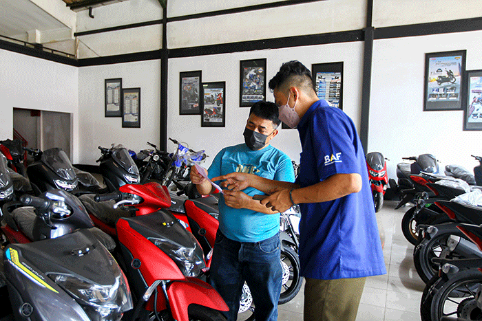 Sales menawarkan motor ke calon konsumen di salah satu dealer motor di kawasan Cibubur, Jakarta Timur, Kamis (3/3/2022).