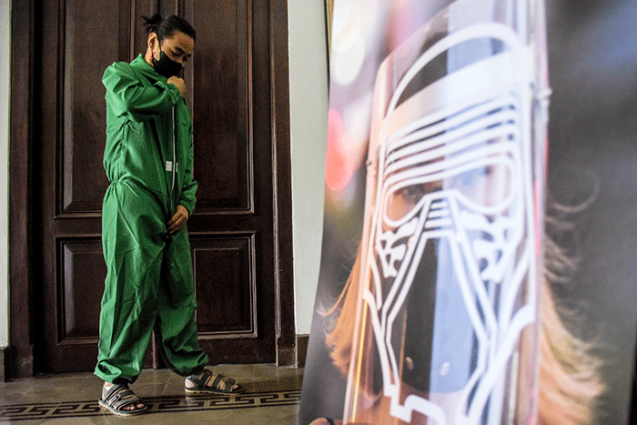 Pengunjung pameran mengenakan pakaian hazmat yang disediakan saat berkunjung ke pameran foto 731 yang diselenggarakan oleh Pewarta Foto Indonesia Bandung.