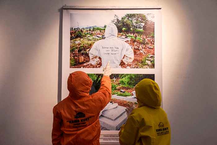 Pengunjung pameran mengenakan pakaian hazmat yang disediakan saat berkunjung ke pameran foto 731 yang diselenggarakan oleh Pewarta Foto Indonesia Bandung.