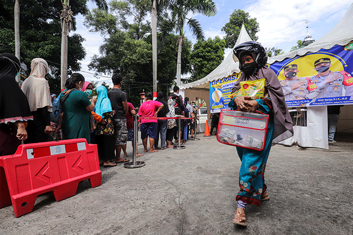 Warga antre minyak goreng saat operasi pasar di Polsek Tebet, Jakarta Selatan, Sabtu (5/3/2022).