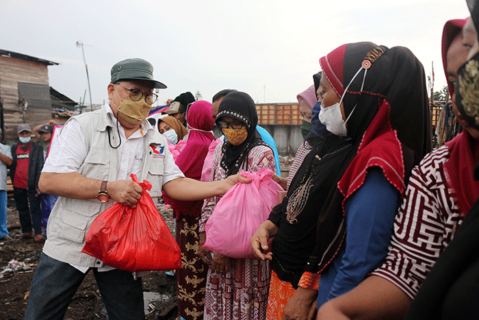 Ketua DPP Perindo Bidang Sosial & Kesra Yerry Tawalujan memberikan sembako kepada warga nelayan di Kalibaru, Cilincing, Jakarta Utara, Selasa (8/3/2022).