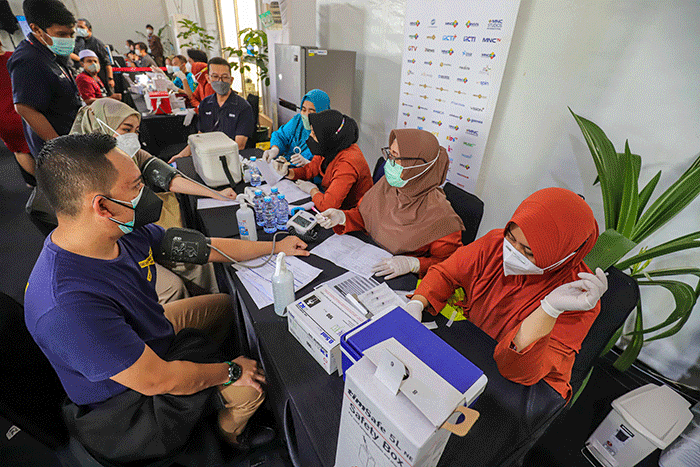 Vaksinator menyuntikkan vaksin dosis ketiga (booster) Covid-19 kepada warga di Sentra Vaksinasi MNC Peduli di kawasan MNC Studios, Kebon Jeruk.