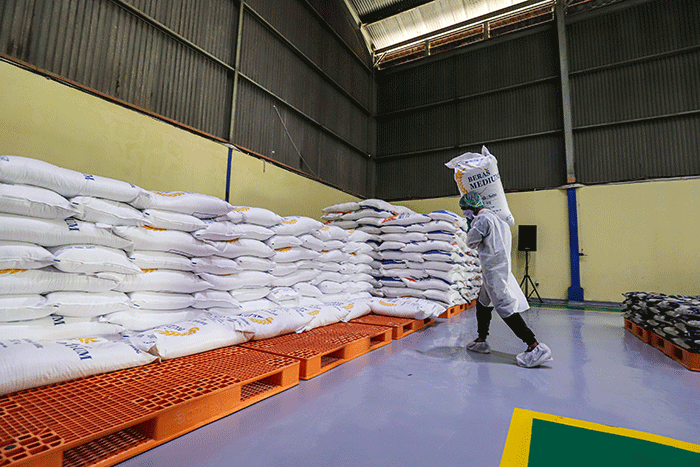 Pekerja mengoperasikan mesin Rice To Rice (RTR) untuk mengisi karung beras medium di Gudang RTT Bulog, Kelapa Gading, Jakarta Utara, Jumat (11/3/2022).