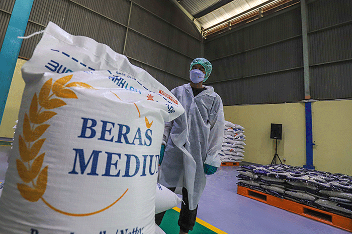 Pekerja mengoperasikan mesin Rice To Rice (RTR) untuk mengisi karung beras medium di Gudang RTT Bulog, Kelapa Gading, Jakarta Utara, Jumat (11/3/2022).