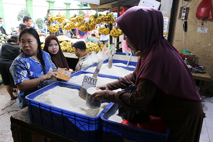 Pedagang beras melayani pembeli di kawasan Pasar Inpres Serdang, Kemayoran, Jakarta, Sabtu (12/3/2022).