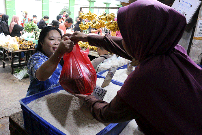 Pedagang beras melayani pembeli di kawasan Pasar Inpres Serdang, Kemayoran, Jakarta, Sabtu (12/3/2022).