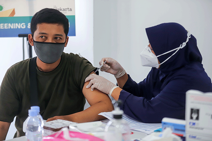 Vaksinator menyuntikkan vaksin Covid-19 dosis ketiga (Booster) kepada warga di Lotte Mart, Kelapa Gading, Jakarta Utara, Sabtu (12/3/2022).