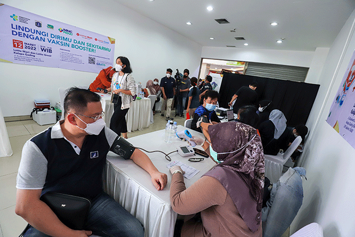 Vaksinator menyuntikkan vaksin Covid-19 dosis ketiga (Booster) kepada warga di Lotte Mart, Kelapa Gading, Jakarta Utara, Sabtu (12/3/2022).