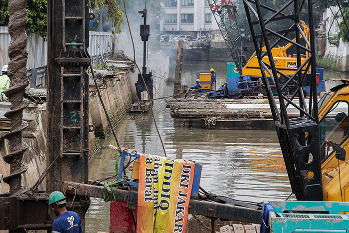 Pekerja menyelesaikan pemasangan dinding turap di kali pasar baru, Jakarta, Sabtu (12/3/2022).