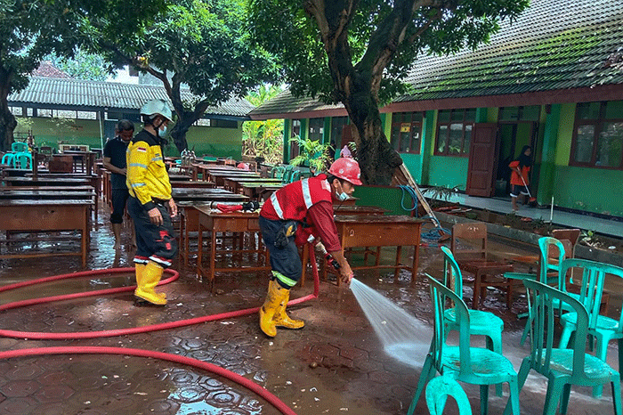Tim Keselamatan dan Kesehatan Kerja (K3) SIG membantu membersihkan fasilitas umum yang terendam lumpur akibat banjir.